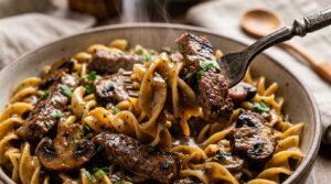 Ultra close-up macro of tender seared halal beef strips and mushrooms in velvety sour cream sauce over buttered egg noodles