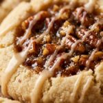 Ultra close-up macro of buttery pecan pie shortbread cookie filled with bubbling brown sugar toasted pecans and warm vanilla glaze